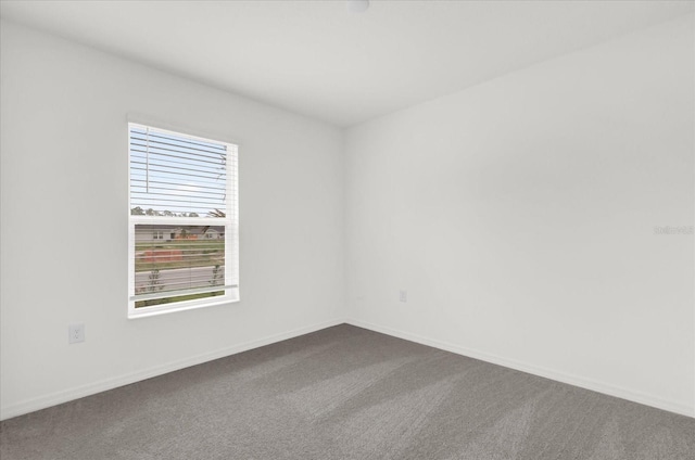 spare room featuring carpet flooring and baseboards