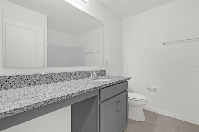 full bath featuring tile patterned flooring, toilet, vanity, baseboards, and a shower