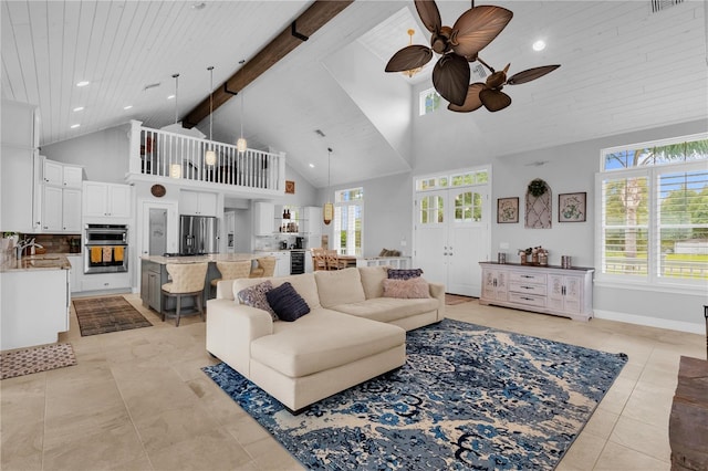 living room featuring ceiling fan, high vaulted ceiling, beam ceiling, and light tile patterned flooring