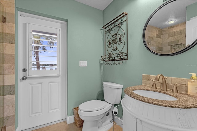 bathroom with vanity, toilet, tile patterned floors, and a shower