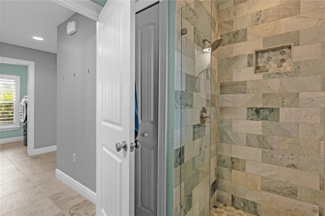 bathroom featuring tiled shower and washer / clothes dryer