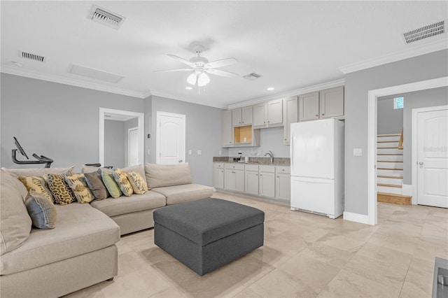 tiled living room featuring sink, crown molding, and ceiling fan