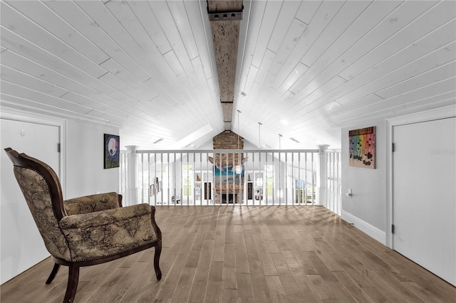 living area featuring vaulted ceiling with beams, hardwood / wood-style flooring, wood ceiling, ceiling fan, and floor to ceiling windows