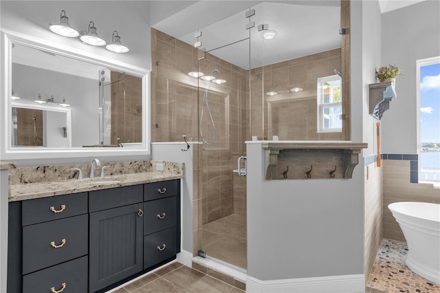 bathroom featuring vanity, tile patterned floors, tile walls, and plus walk in shower