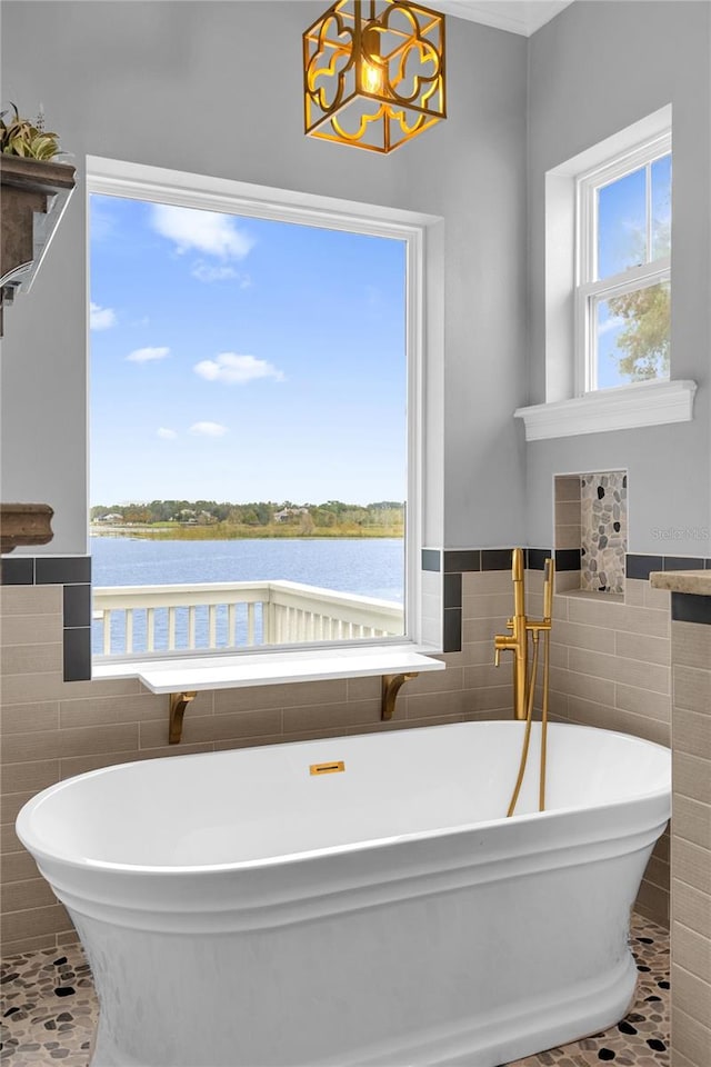 bathroom with a water view, a tub to relax in, and tile patterned flooring