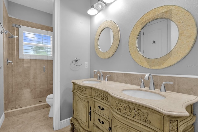 bathroom featuring toilet, vanity, tile patterned floors, and a shower with door