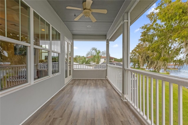 unfurnished sunroom featuring a water view and ceiling fan