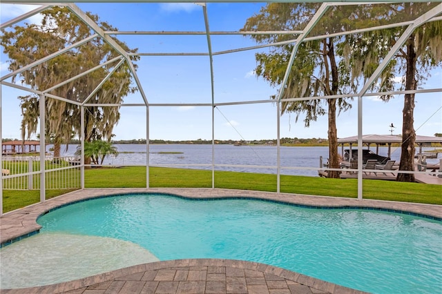 view of pool with a water view, a lanai, and a yard