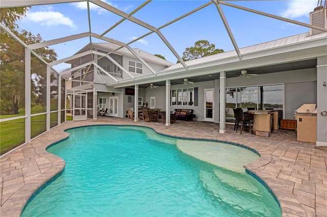 view of swimming pool featuring a patio area, glass enclosure, and ceiling fan