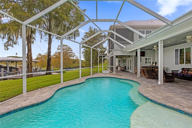 view of swimming pool with a yard, ceiling fan, a patio area, and a lanai