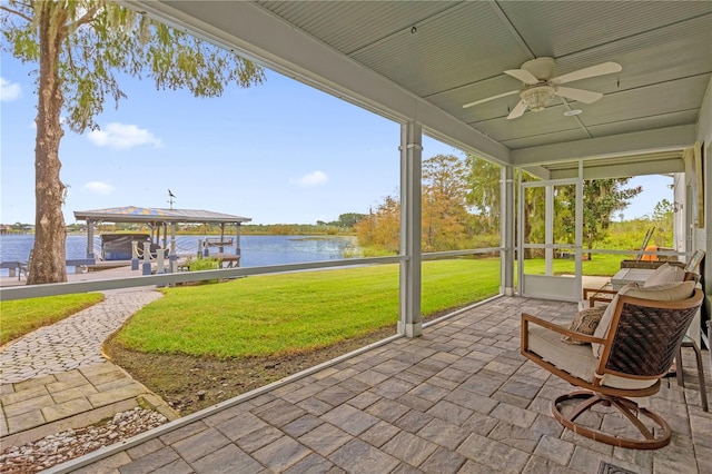 sunroom with a water view and ceiling fan