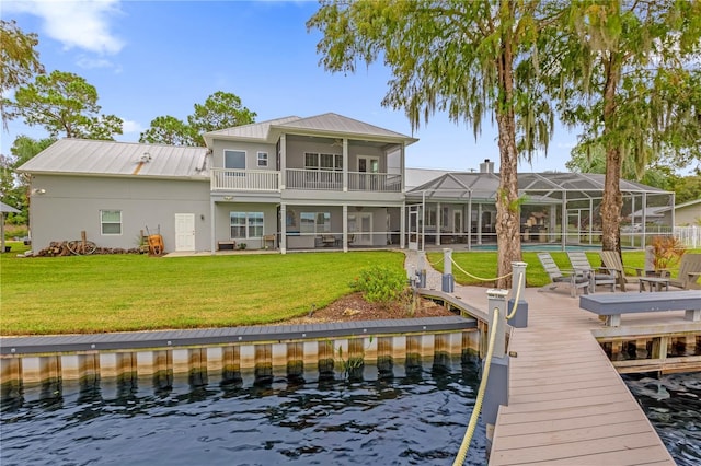 rear view of property with a yard, a lanai, a patio area, a water view, and a balcony