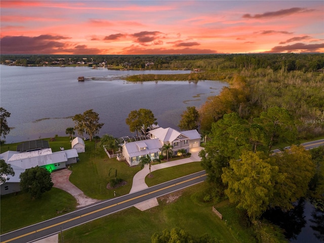 aerial view at dusk featuring a water view