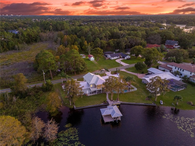 aerial view at dusk featuring a water view