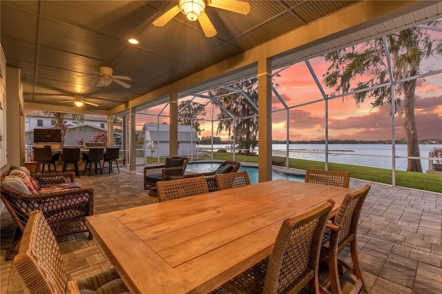 sunroom / solarium featuring a swimming pool, a water view, a healthy amount of sunlight, and ceiling fan