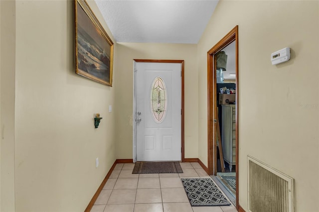 tiled foyer featuring a textured ceiling and vaulted ceiling