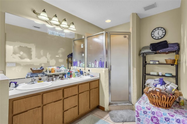 bathroom featuring a shower with door, vanity, and tile patterned floors