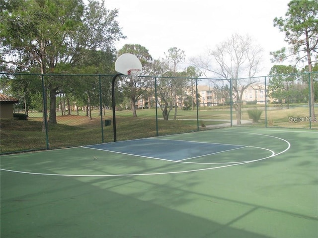 view of sport court featuring a lawn