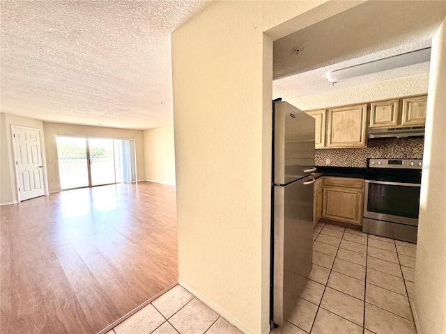 13803 Fairway Island Dr Unit 1627, Orlando, FL 32837 - kitchen with stainless steel appliances, a textured ceiling, open floor plan, under cabinet range hood, and light tile patterned floors
