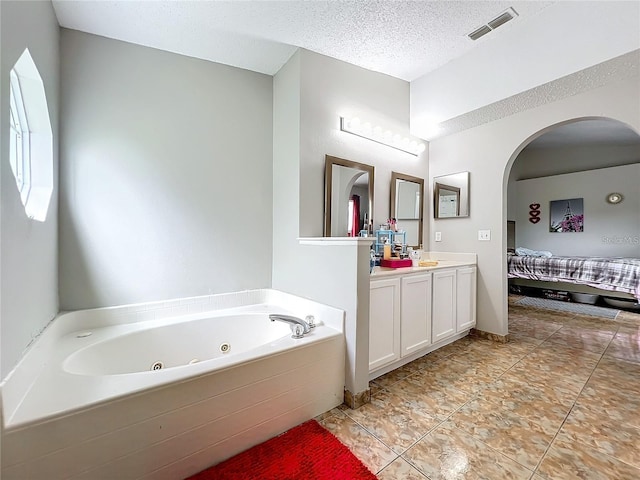 bathroom with vanity, tile patterned floors, a textured ceiling, and a bath