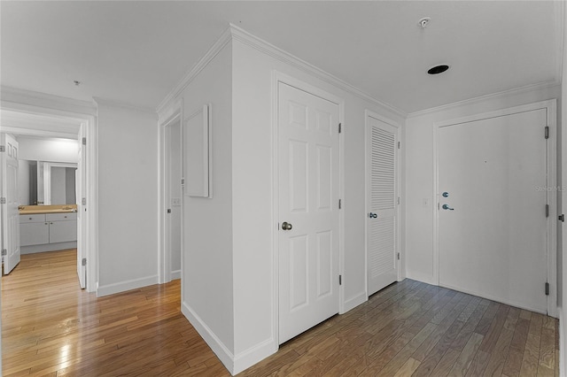 hallway with hardwood / wood-style flooring and ornamental molding