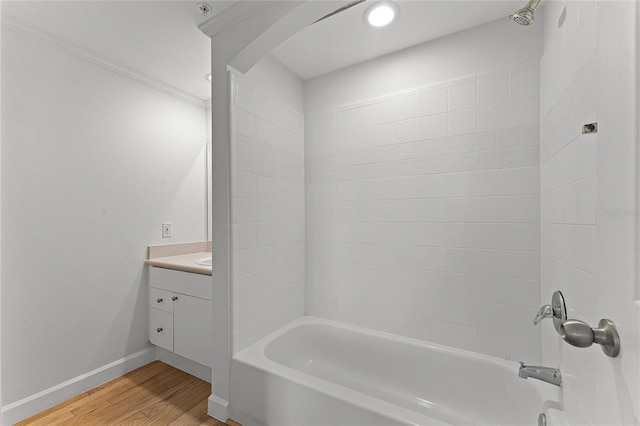 bathroom with tiled shower / bath, vanity, ornamental molding, and wood-type flooring