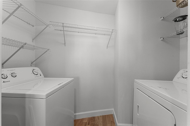 washroom featuring washing machine and clothes dryer and wood-type flooring