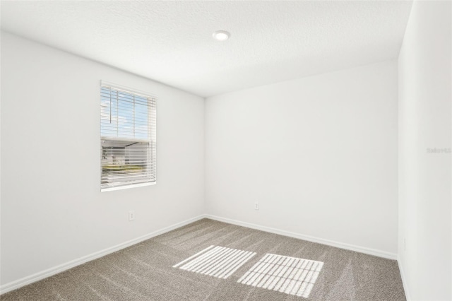 carpeted empty room with a textured ceiling