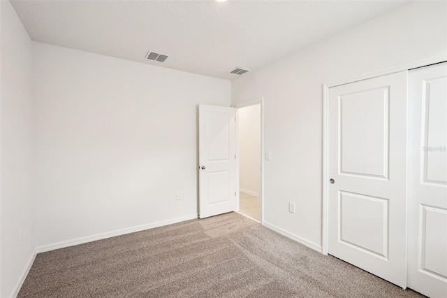 unfurnished bedroom with light carpet and a closet