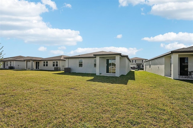 back of house featuring a lawn and central air condition unit