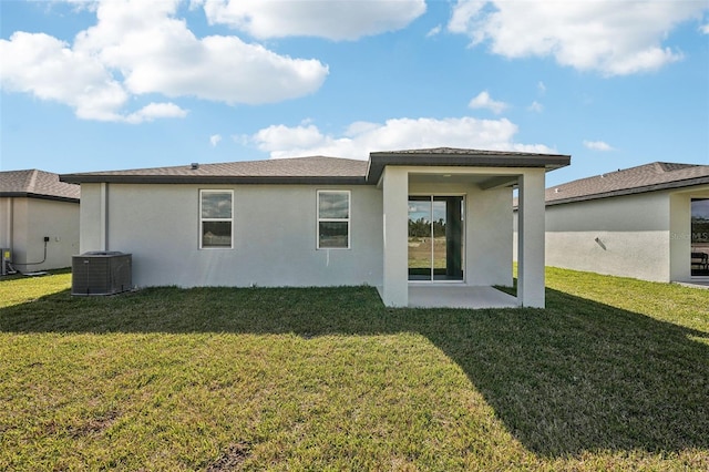 back of property with a lawn, a patio area, and cooling unit