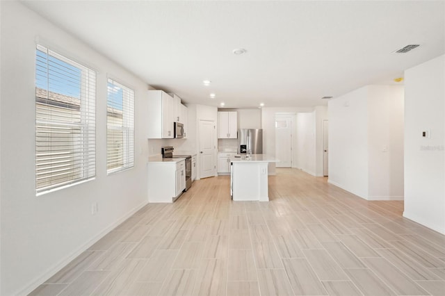 kitchen featuring white cabinets, a kitchen island, and stainless steel appliances