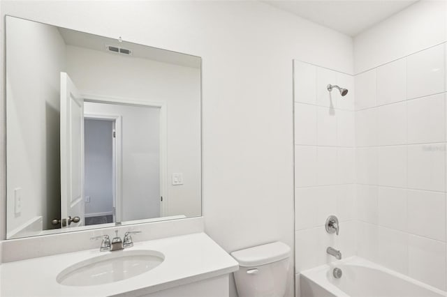 full bathroom featuring vanity, tiled shower / bath combo, and toilet