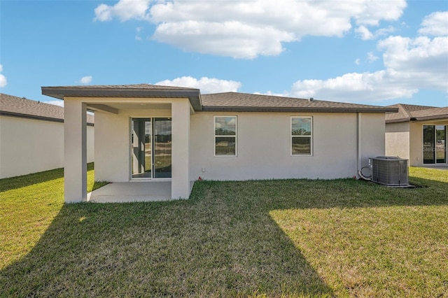 rear view of property featuring a lawn, cooling unit, and a patio area