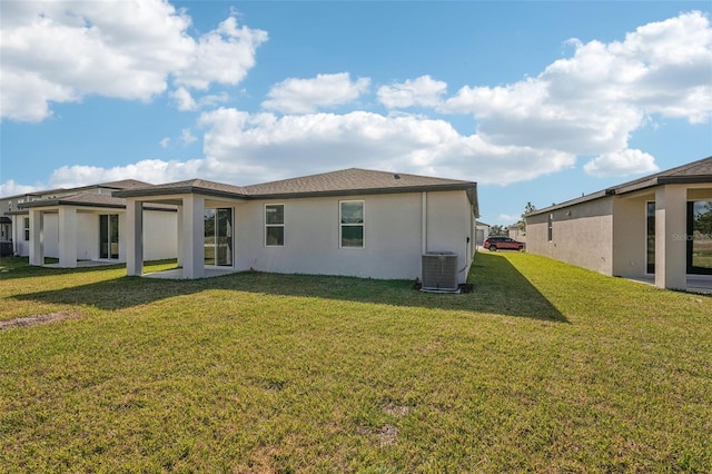 rear view of house with a lawn and central AC unit