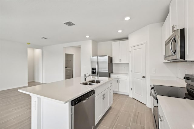 kitchen with white cabinetry, sink, a center island with sink, and stainless steel appliances