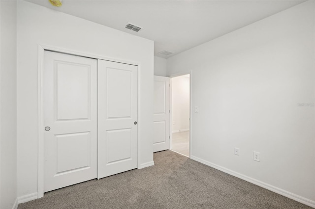 unfurnished bedroom featuring carpet flooring and a closet