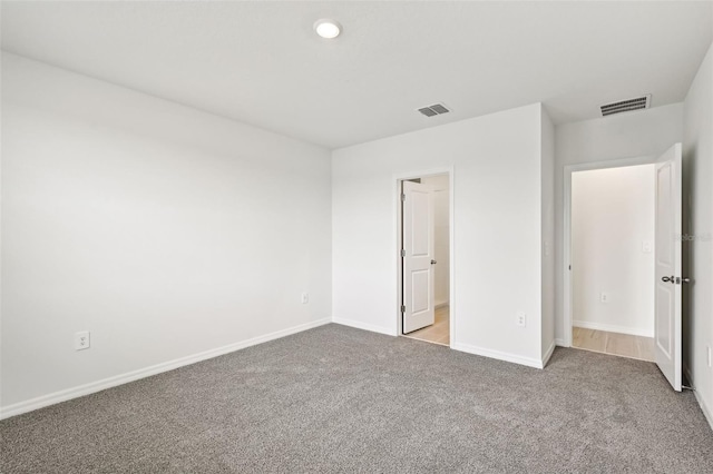 unfurnished bedroom with light colored carpet and connected bathroom