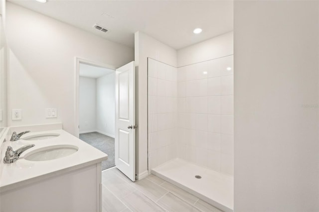 bathroom with vanity and a tile shower