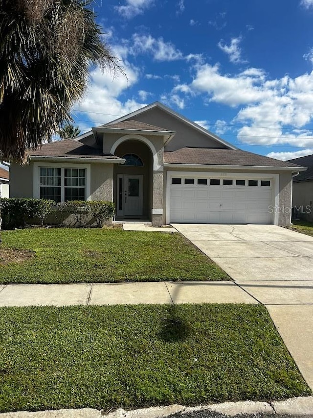 view of front of house with a front yard and a garage