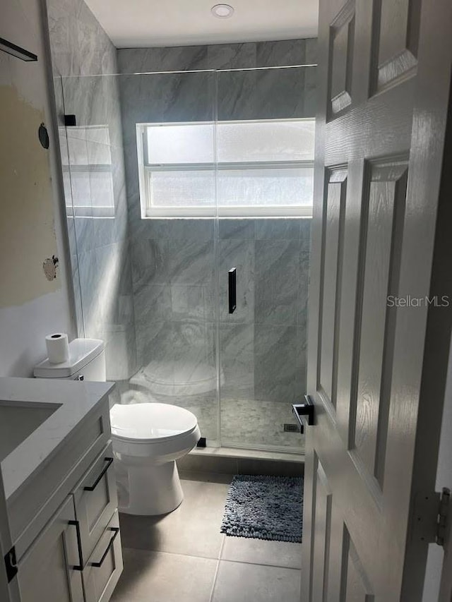 bathroom featuring an enclosed shower, toilet, tile patterned floors, tile walls, and vanity