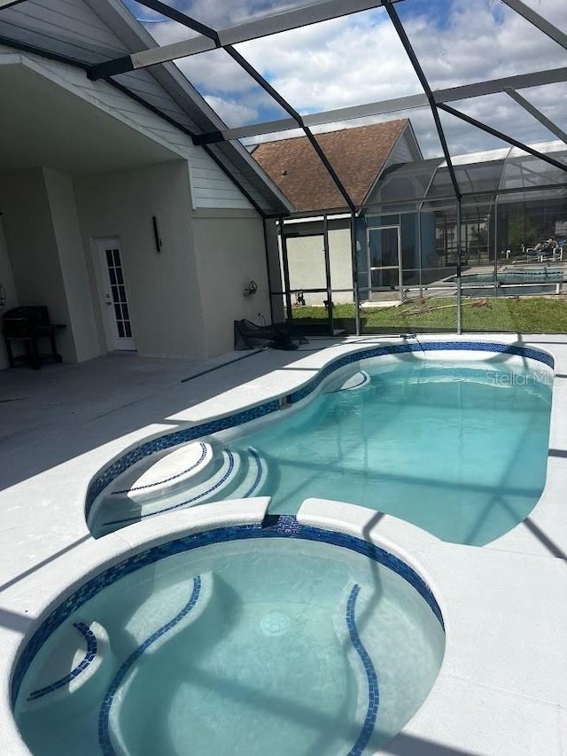 view of swimming pool featuring a patio and a lanai