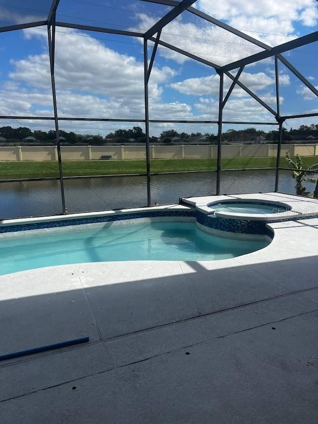 view of pool featuring a patio, a lanai, an in ground hot tub, and a water view