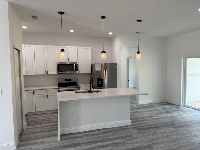 kitchen with sink, hardwood / wood-style floors, a center island with sink, white cabinets, and appliances with stainless steel finishes