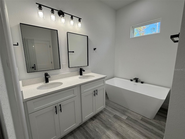 bathroom featuring vanity, wood-type flooring, and a tub to relax in