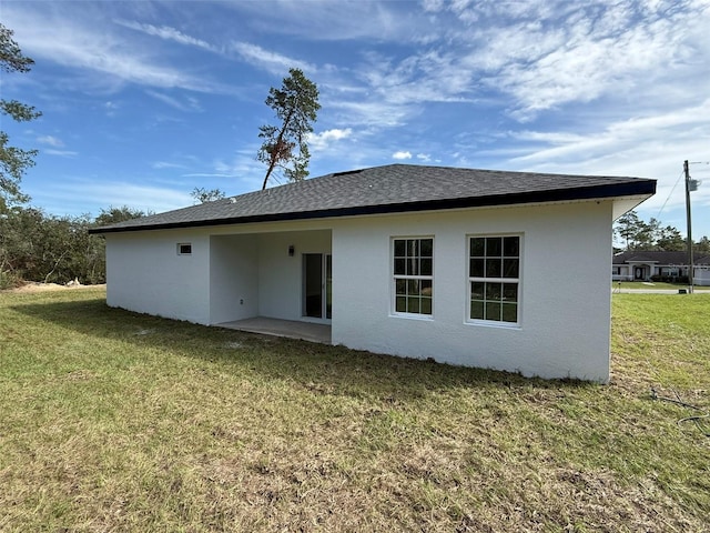 rear view of house with a yard and a patio