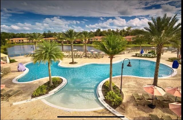 view of swimming pool with a patio and a water view