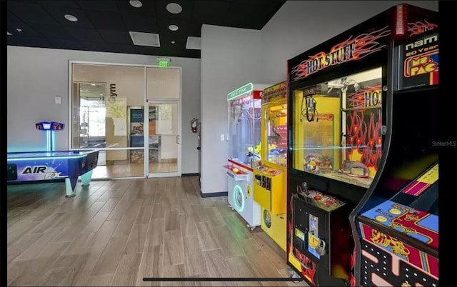 game room with hardwood / wood-style floors and a paneled ceiling