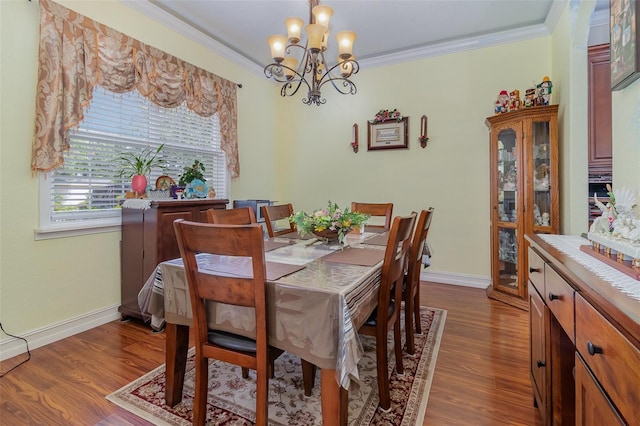 dining area with dark hardwood / wood-style flooring, crown molding, and a chandelier