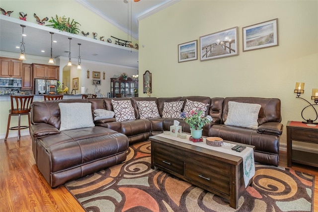 living room featuring crown molding, wood-type flooring, and vaulted ceiling